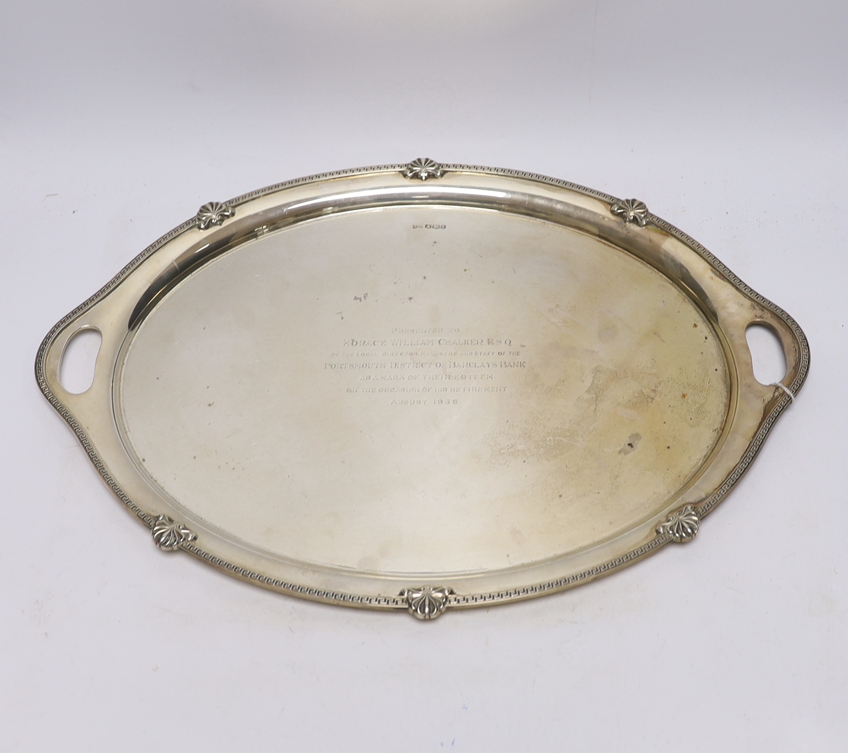 A George V silver oval presentation tea tray, with inset handles, Walker & Hall, Sheffield, 1935, 49.4cm, 54.2oz.